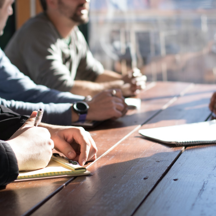 people sitting at table taking notes